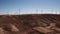 Dolly zoom over huge windmill farm in summer