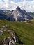 Dolomites mountains with meadow, chalet, peaks and hiking trail
