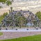 Dome climbing frame against trees homes and sky