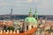 Dome and clock tower of old baroque. Roofs of houses and buildings of Prague.