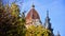 The dome of a European architectural building against a background of autumn trees. Concept: the beginning of the heating season,