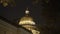Dome with illumination of St. Isaac`s Cathedral at night. Action. Close-up of beautiful dome with yellow illumination at
