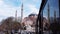 Dome of mosque with tower, sky among city, reflected in window bus Tour istanbul