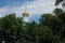 The dome of the Orthodox church over the trees. Golden dome against the blue sky