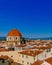 Dome of San Lorenzo Basilica under blue sky, over houses of the historical center of Florence, Italy