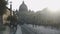 Dome of St Peter\'s Basilica church in sunset beams, tourists walking to Vatican