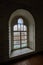 Domes of the old church are visible through the arched window of the old tower