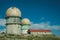 Domes of old radar station and house on rocky place