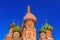 Domes of St. Basil`s Cathedral on a blue sky background. Moscow in winter