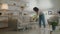 Domestic chores. Young african american woman washing floor with mop, making home cleaning at living room, free space