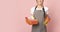 Domestic cleaning services. Smiling housemaid in apron with household supplies in hands