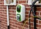 Domestic electric vehicle charging point fitted on the wall of new build house as part of the program to reduce the emission