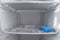 Domestic fridge freezer defrost problem concept. Front view of refrigerator covered with ice. Appliance repair concept