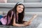 Domestic hobbies concept. Cheerful Indian teenage girl reading exciting book, lying on soft carpet at home