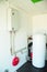 A domestic household boiler room with a new modern gas boiler, heating electric warm water system and pipes