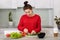 Domestic life and motherhood concept. Busy pregnant woman cuts vegetables for making salad, poses in modern apartment against