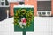 Domestic mail box decorated with spruce tree Christmas wreath outdoors in snowy winter day.