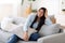 Domestic Portrait. Cheerful Korean Woman Posing On Comfy Couch At Home