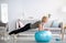 Domestic sports. Athletic mature woman standing in plank on fitness ball, working out core muscles at home