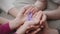 Domestic violence awareness symbol. Close up shot of parents and children hands holding purple ribbon