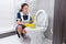 Domestic worker cleaning toilet edge