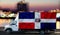 Dominicana flag on the side of a white van against the backdrop of a blurred city and river. Logistics concept