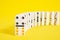 Domino knuckles on a yellow background, domino effect