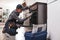 Don`t delay with repair. Close-up of repairman examining oven