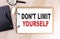 DON\\\'T LIMIT YOURSELF text on clipboard on wooden background