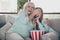 Don`t look. Photo of two people white haired grandma small granddaughter sit sofa watch tv scary horror film hiding eyes