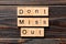 Don`t miss out word written on wood block. Don`t miss out text on wooden table for your desing, Top view concept