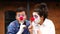 Don`t tell anyone. Two clowns smiling and holding finger on lips making silence gesture, shushing asking to keep secret