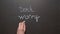 Don`t worry be happy. A hand writes the expression by chalk on a black board