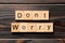 Don`t worry word written on wood block. Don`t worry text on wooden table for your desing, Top view concept