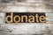 Donate Letterpress Word on Wooden Background