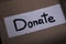 `Donate` sign handwritten with black letters in a box. donation concept. Context of The Coronavirus Pandemic. copy space