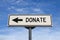 Donate white road sign with arrow, arrow on blue sky background