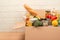 Donation box with different groceries, food donations on light background with copyspace - pasta, fresh vegatables, canned food,