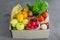 Donation box with fresh organic fruits, vegetables and herbs on a concrete background. Proper nutrition.