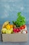 Donation box with fresh organic fruits, vegetables and herbs on a concrete background. Proper nutrition.