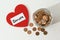 Donation jar, coins and red heart on white background,