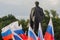 Donetsk, Ukraine - June 12, 2019: Flags of Russia and the monument to Vladimir Lenin on the central square