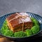 Dong Po Rou Dongpo pork meat in a beautiful plate with green vegetable, traditional festive food for Chinese new year