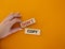 Dont copy symbol. Wooden blocks with words Dont copy. Beautiful orange background. Businessman hand. Business and Dont copy