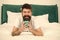 Dont hurry drink coffee. Happy hipster drink coffee in bed. Bearded man enjoy hot drink. Breakfast drink. Good coffee
