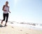 Dont let a weak mind spoil a good work out. a young woman taking a jog on the beach.