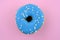 Donut with blue icing and beads top view.