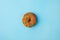 Donut glazed with sprinkles on a blue background. Modern flat lay photo pattern in pop art style, party food.