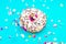 Donut icing chocolate straws blue multicolored confetti background. Holiday celebration concept