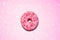 Donut on pink background. Strawberry sprinkles on sugar glazed dessert. Girly, candy, pastry, sweet fast food, bakery